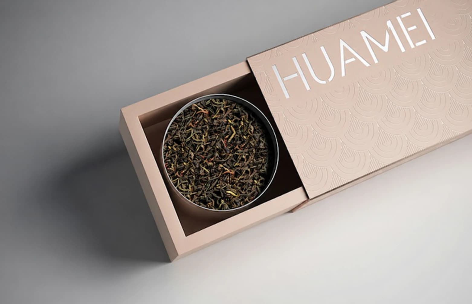 Text-edited reference photo of a partially shown blush drawer box with an arc pattern and a round tea tin